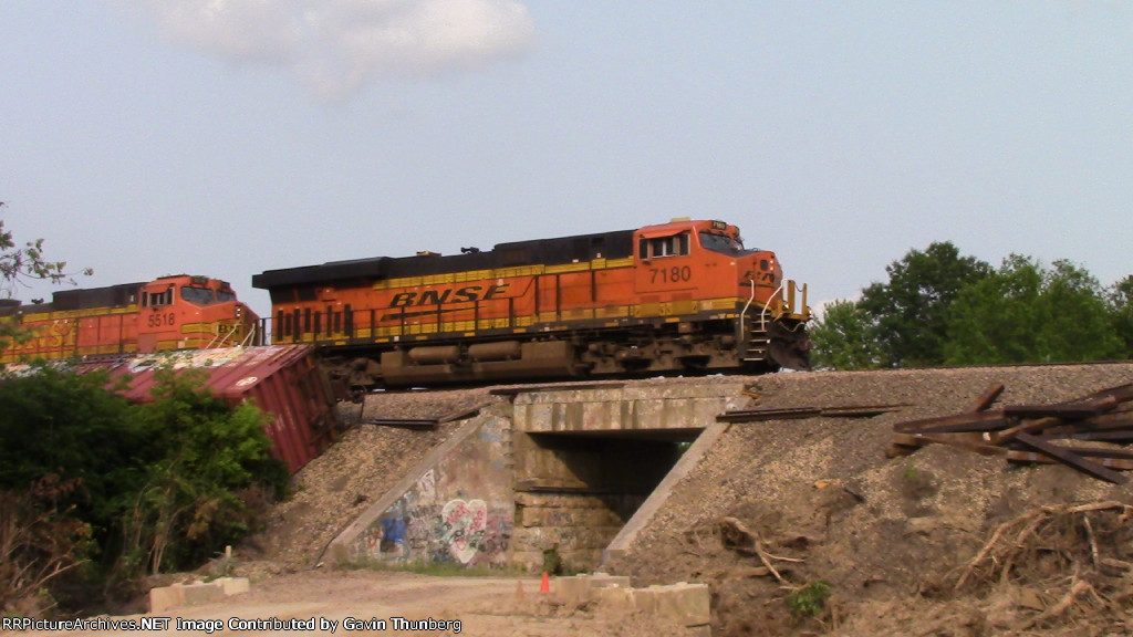 A BNSF freight moves through the derailment site